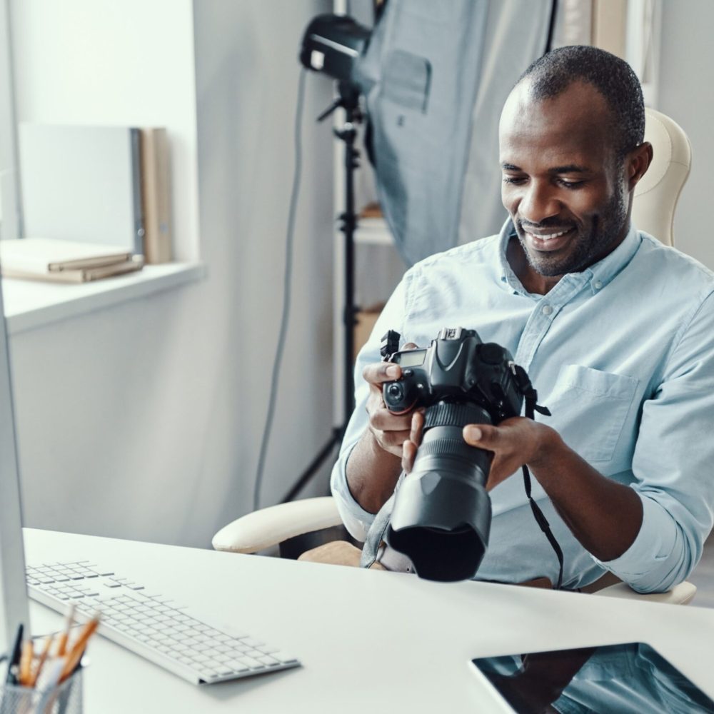 handsome-young-african-man-holding-digital-camera-2023-11-27-05-04-59-utc--scaled.jpg